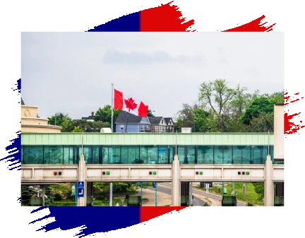 A train traveling over a bridge with canadian flags.